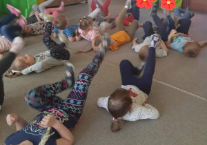 dzieci ćwiczą leżąc na plecach